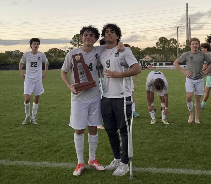 Pier Roca and one of his teammates hold the district championship trophy.