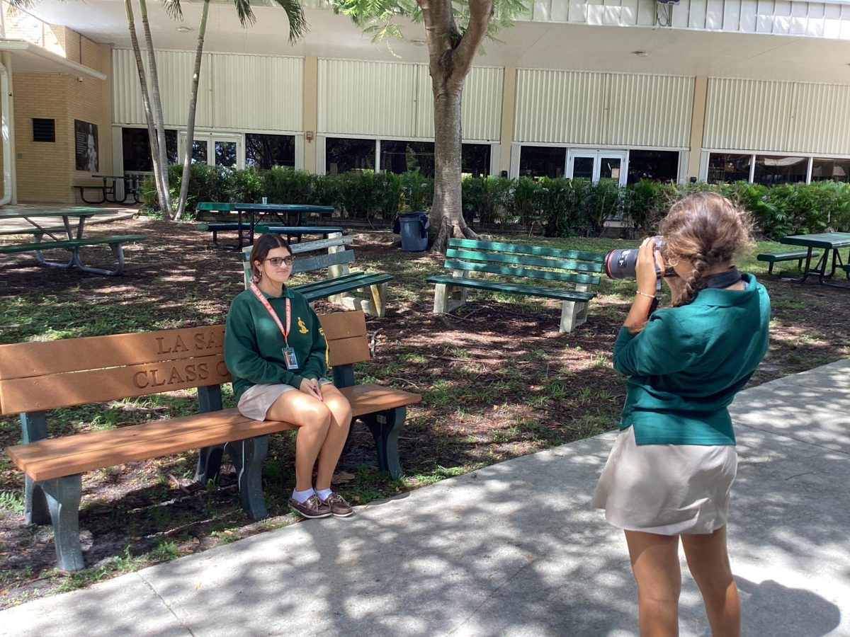 Freshman taking photo of sophmore for photography class.