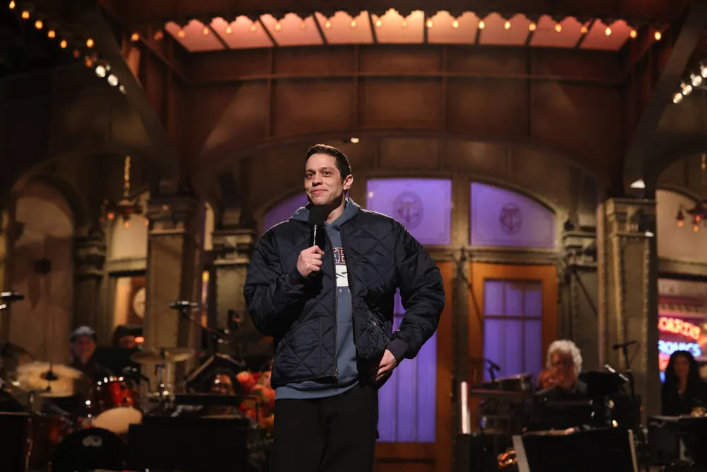 Pete Davidson standing on stage, microphone in hand, hosts the return of Saturday Night Live.