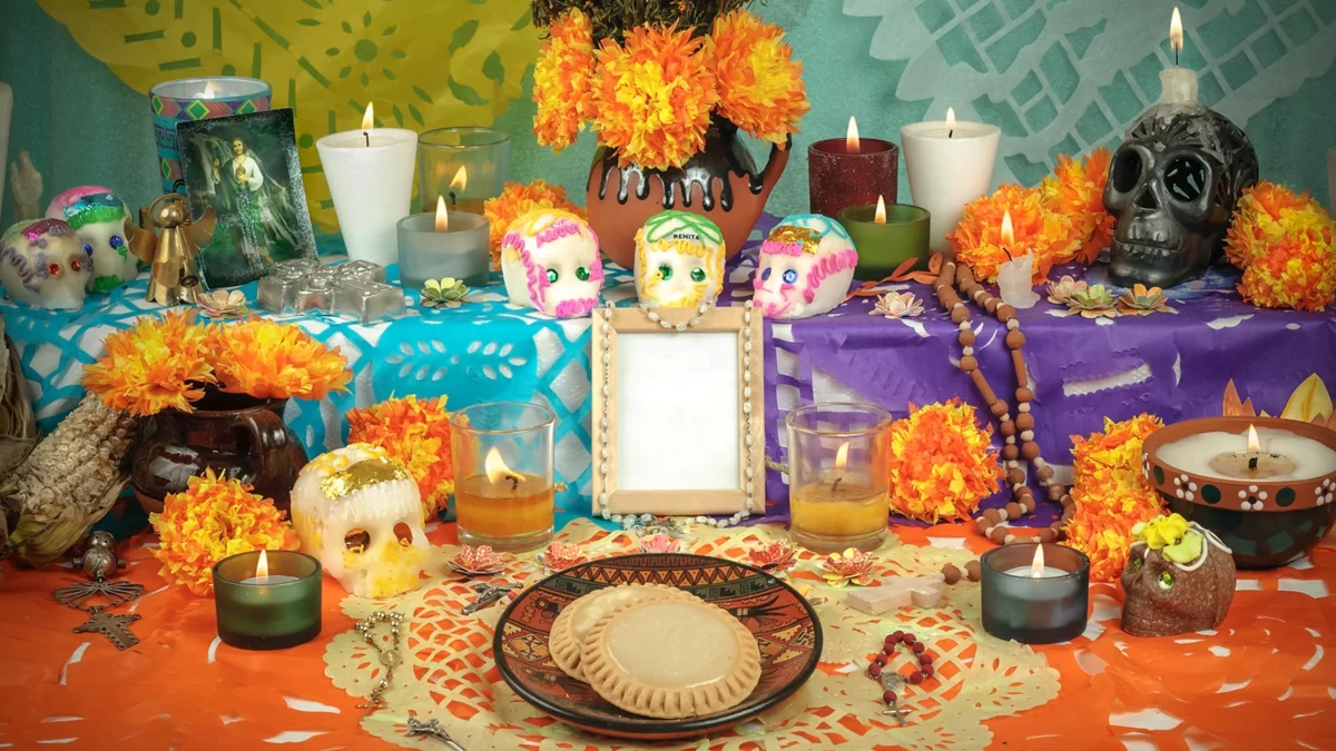 A Mexican Day of the Dead ofrenda is adorned with fake skulls, candles, and food.