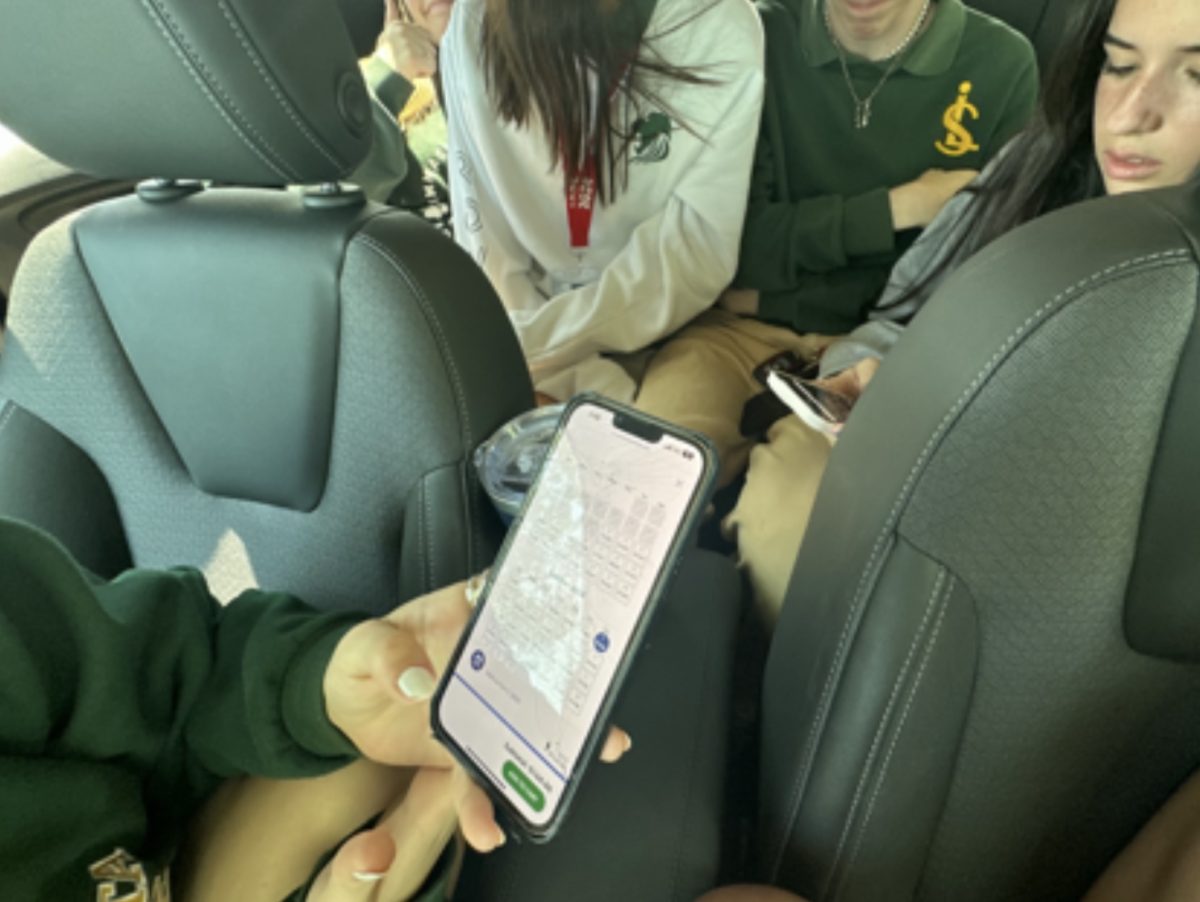 A picture of friends in a car using social media platforms.