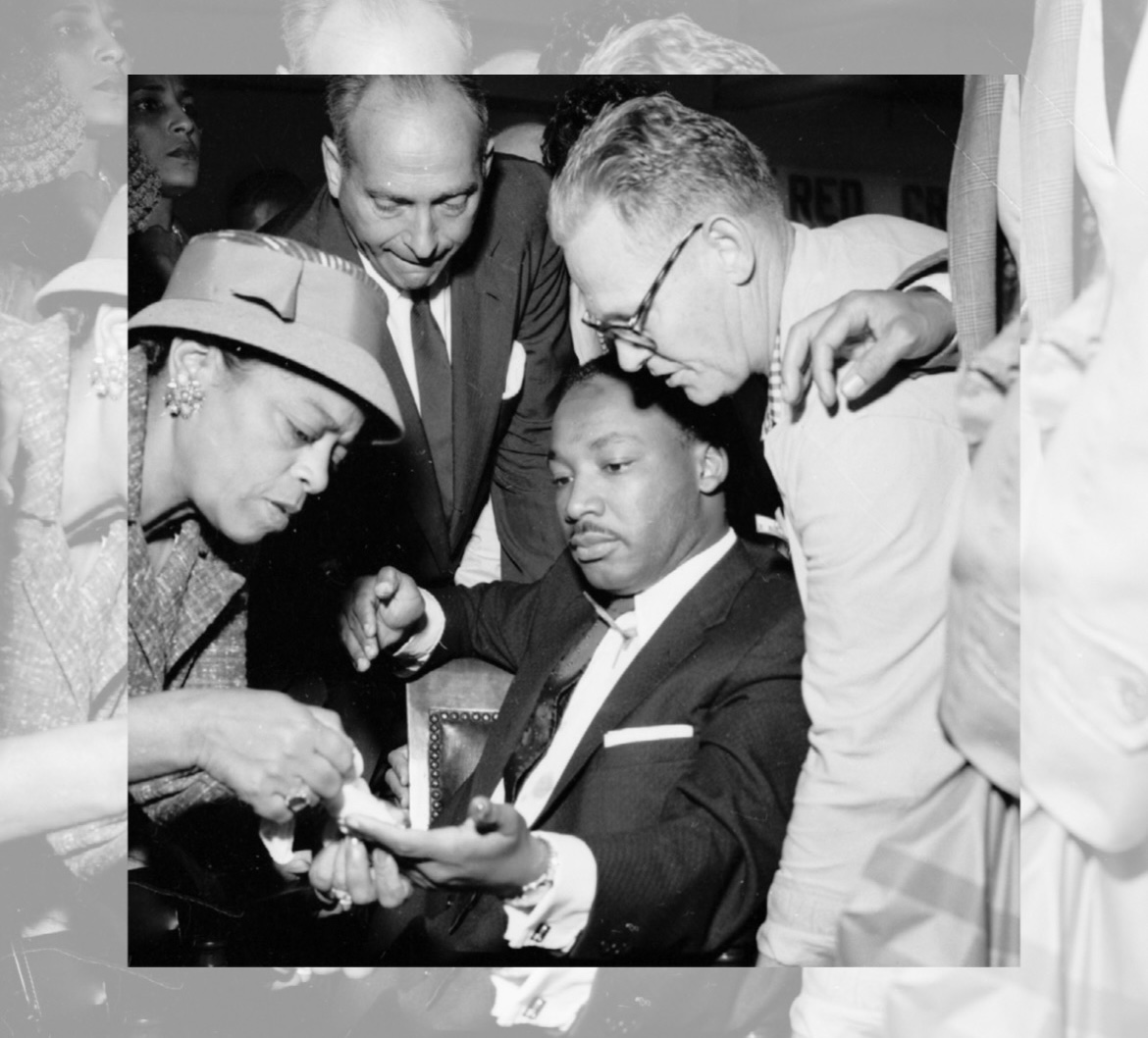 Dr. Martin Luther King, Jr. receives medical aid for a cut on his hand right after a failed assassination attempt.