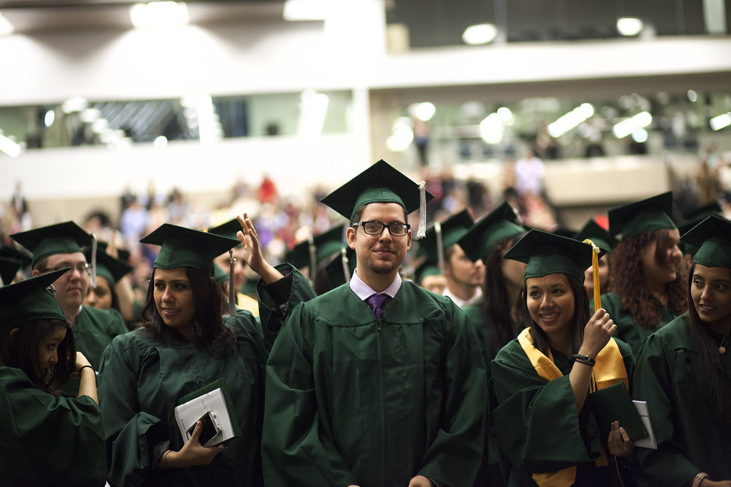 This image of college graduates at a ceremony in the College of DuPage constitutes the culmination of their motivation to earn a bachelors degree.