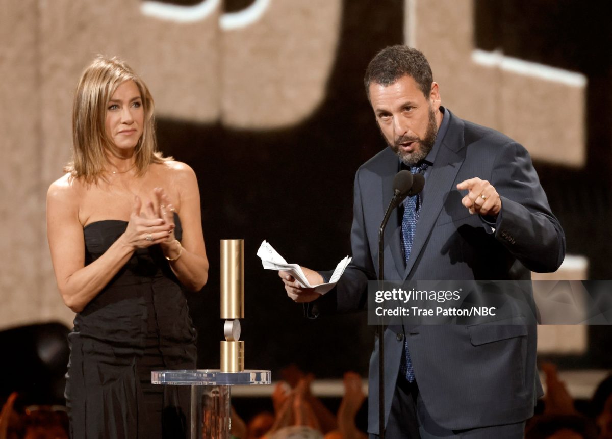 Comedian and actor Adam Sandler delivers his acceptance speech for the People’s Icon Award alongside an emotional Jennifer Aniston. Photo: Getty Images/TraePatton/NBC