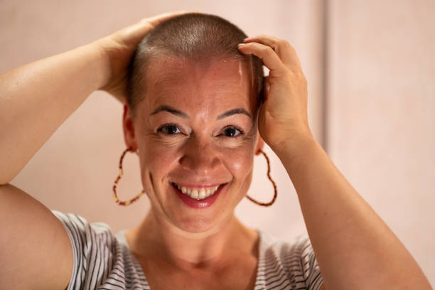 This portrait of a woman undergoing cancer treatment features her touching her shaved head as a show of for support childrens cancer awareness.