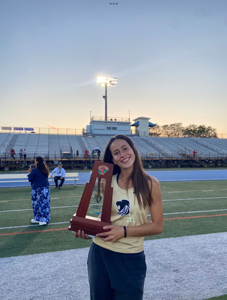 Junior Nahia Riveros holds the runner up trophy for the district championships in Track and Field.