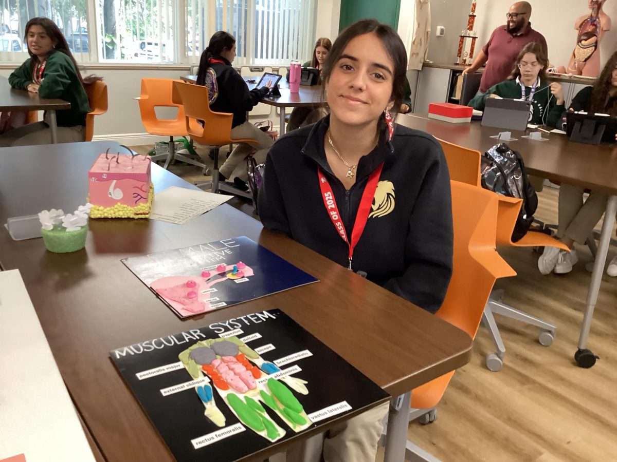 A senior STEAM health student displays her class project on the human body.