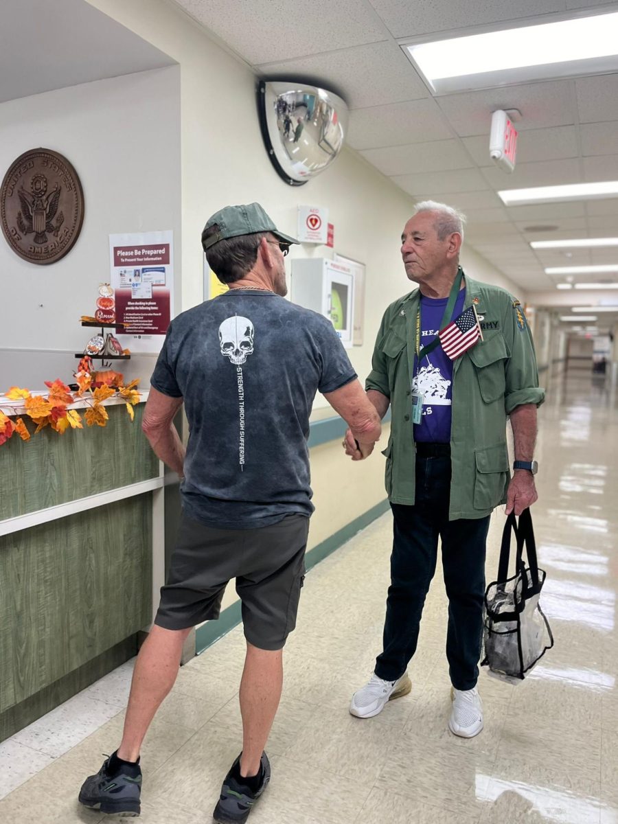 Coach Carmen Grosso, former football coach at ILS and the namesake of the new stadium, greets a veteran.