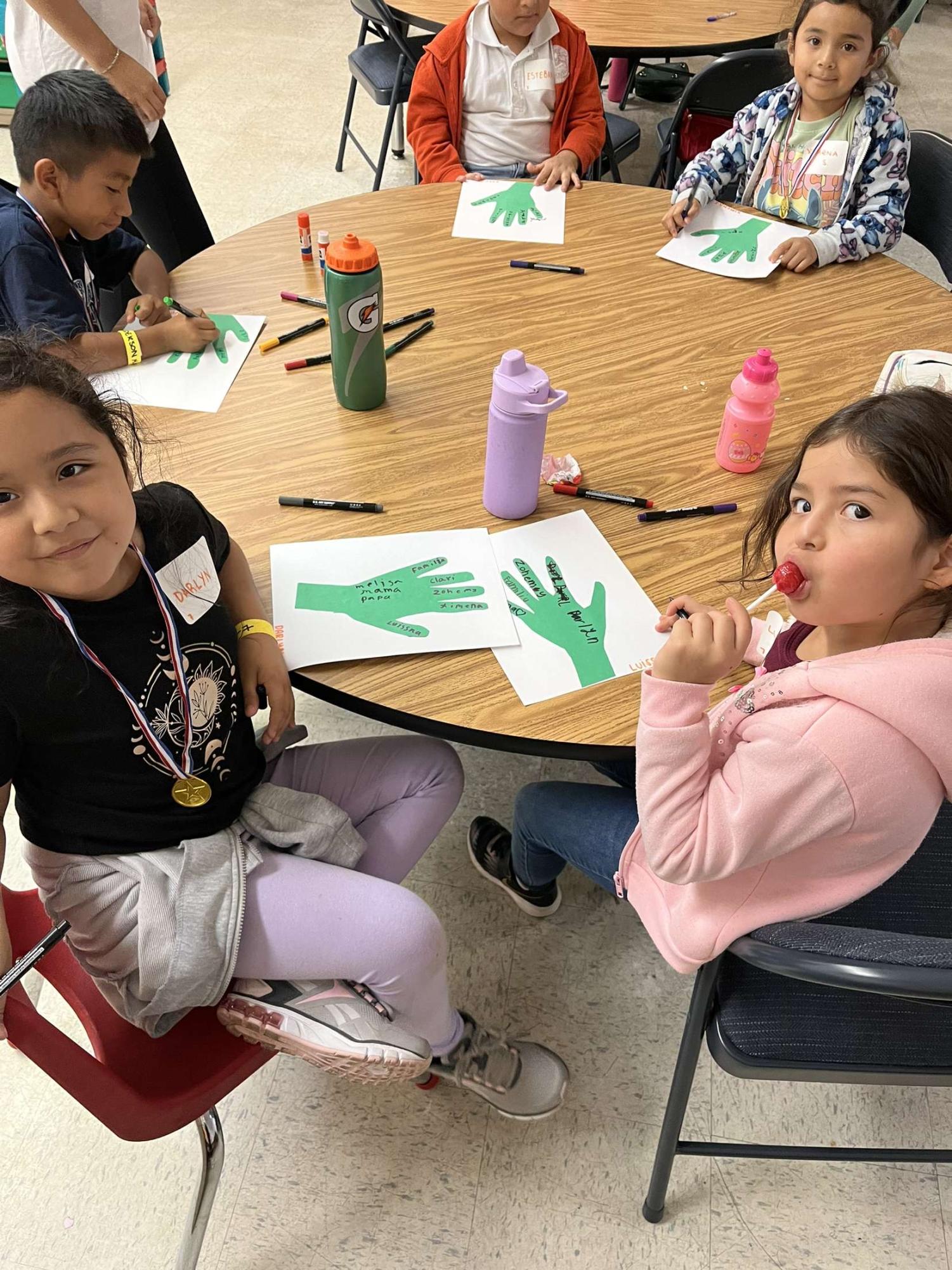 Two little girls at the Maya Center engage in arts and crafts activities.