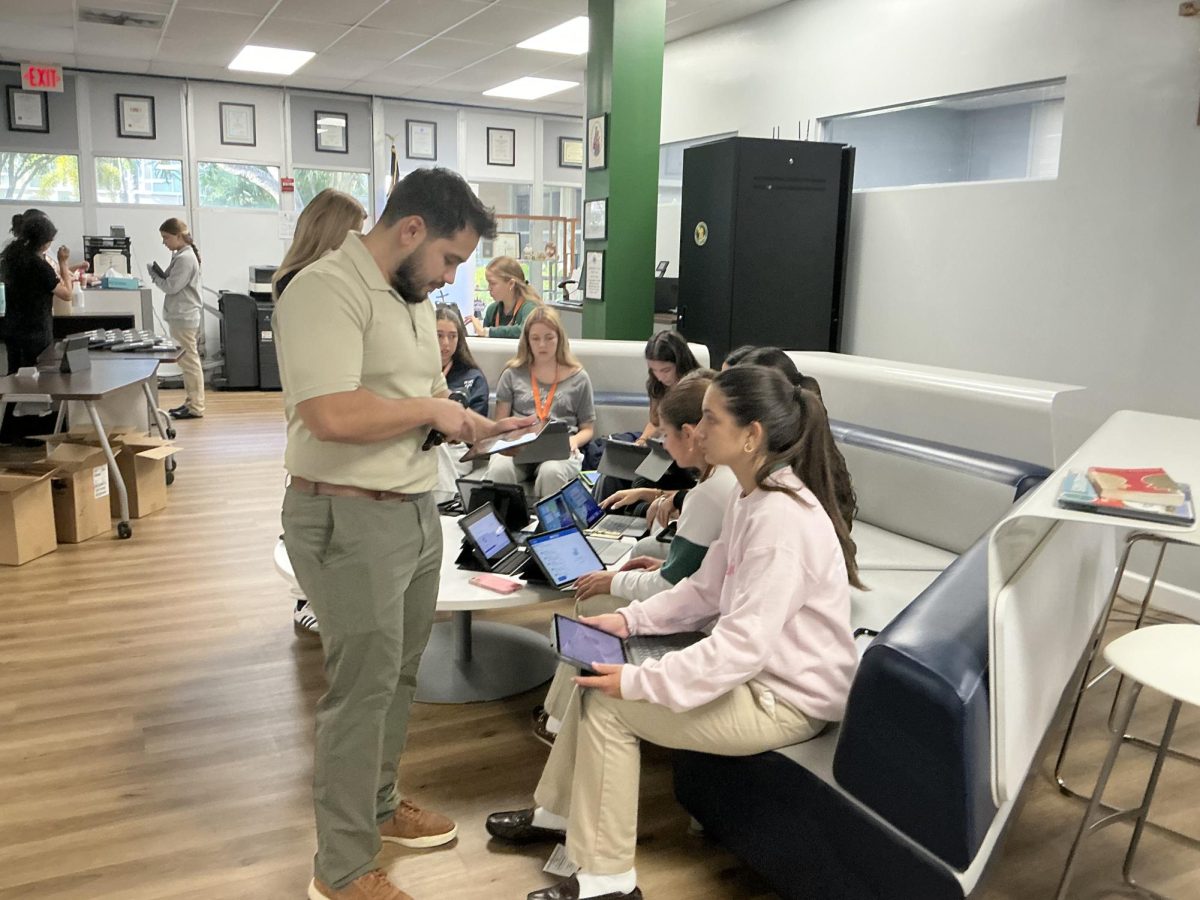 Director of Technology Mr.Daniel Recinos helps Sophomores with with their iPads. One person many new and transfer students will need to interact with is Mr. Recinos as well as the other members of the Technology Department.