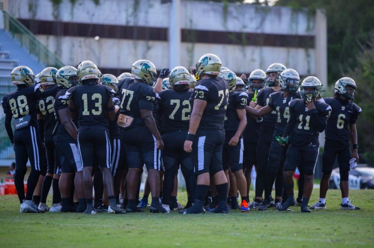 The ILS Football team huddles up before a game.
