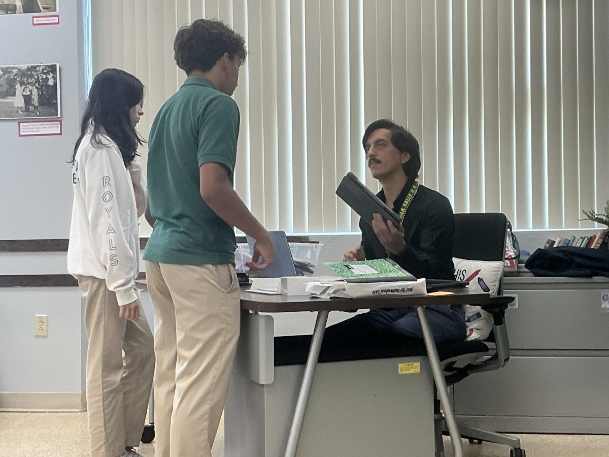 New English teacher, Mr. Alejandro Aguirre, explains a assignment to a couple of his students. 
