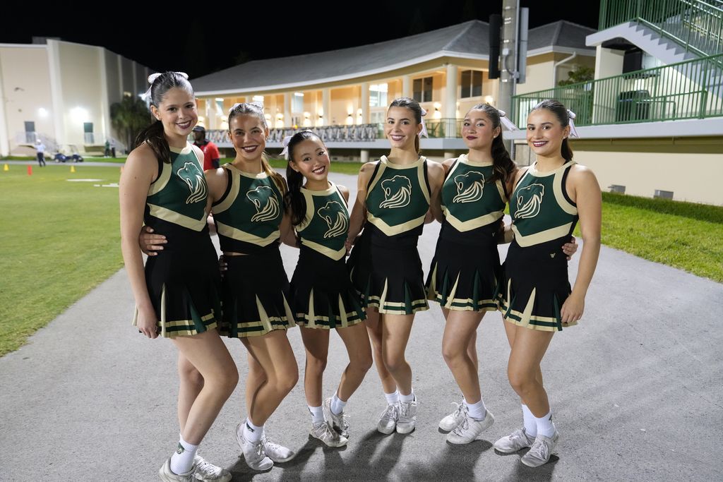 ILS Girls Cheer team bonds after enthusiastically supporting the Varsity Football team.