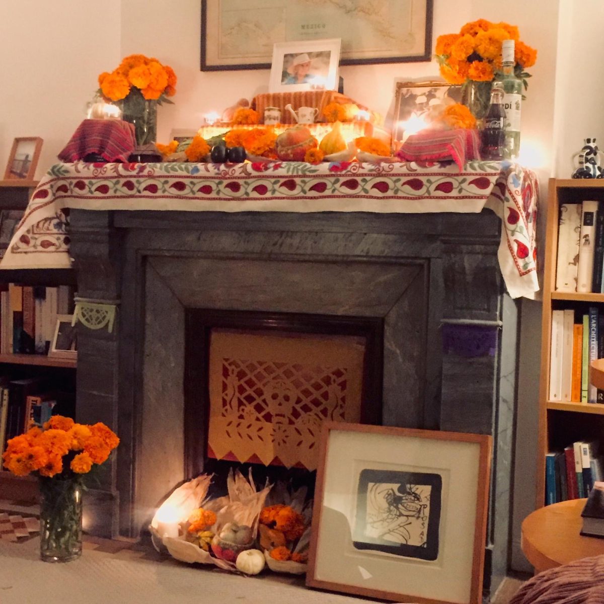 An “ofrenda” for my great-grandmother  Victoria, features her favorite drinks, cempasúchil flowers, candles, and papel picado.