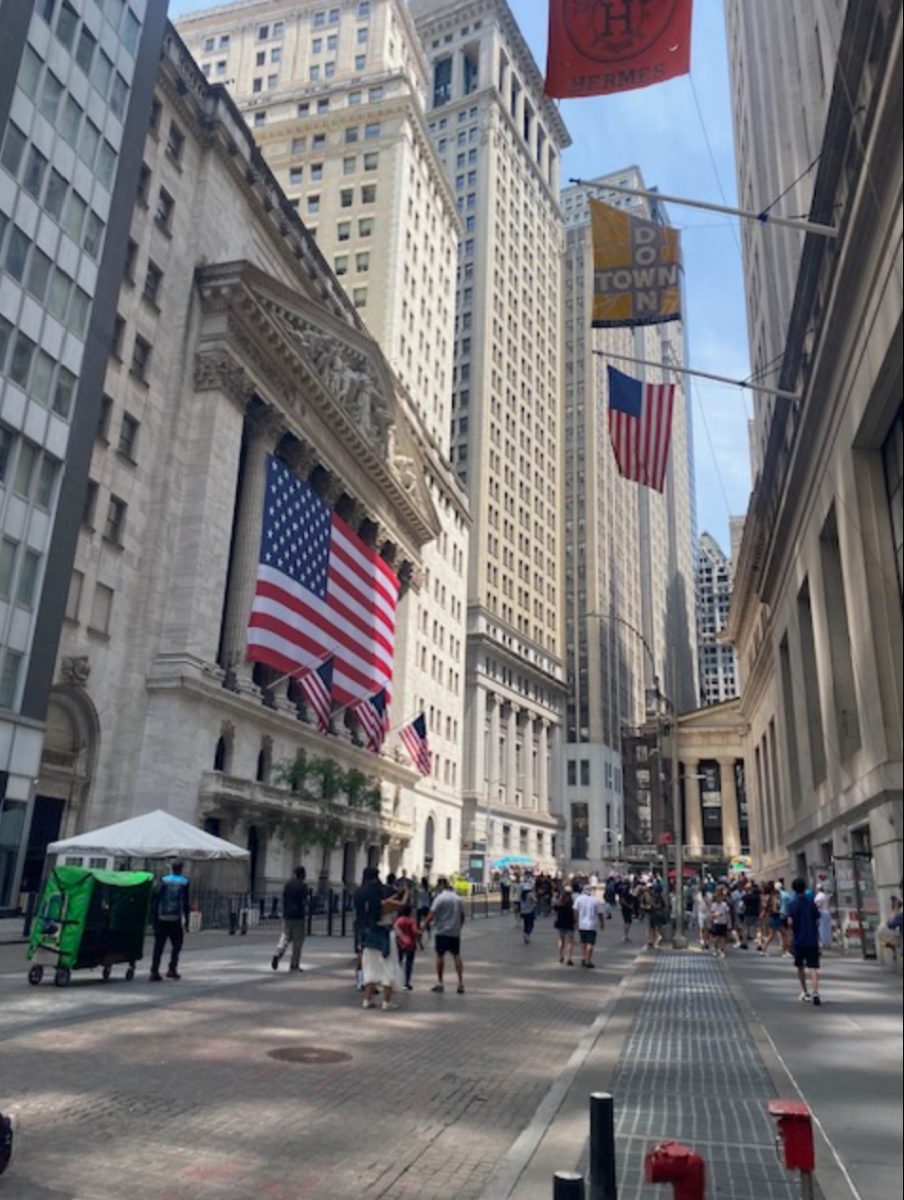 This busy street scene is in front of the New York Stock Exchange.