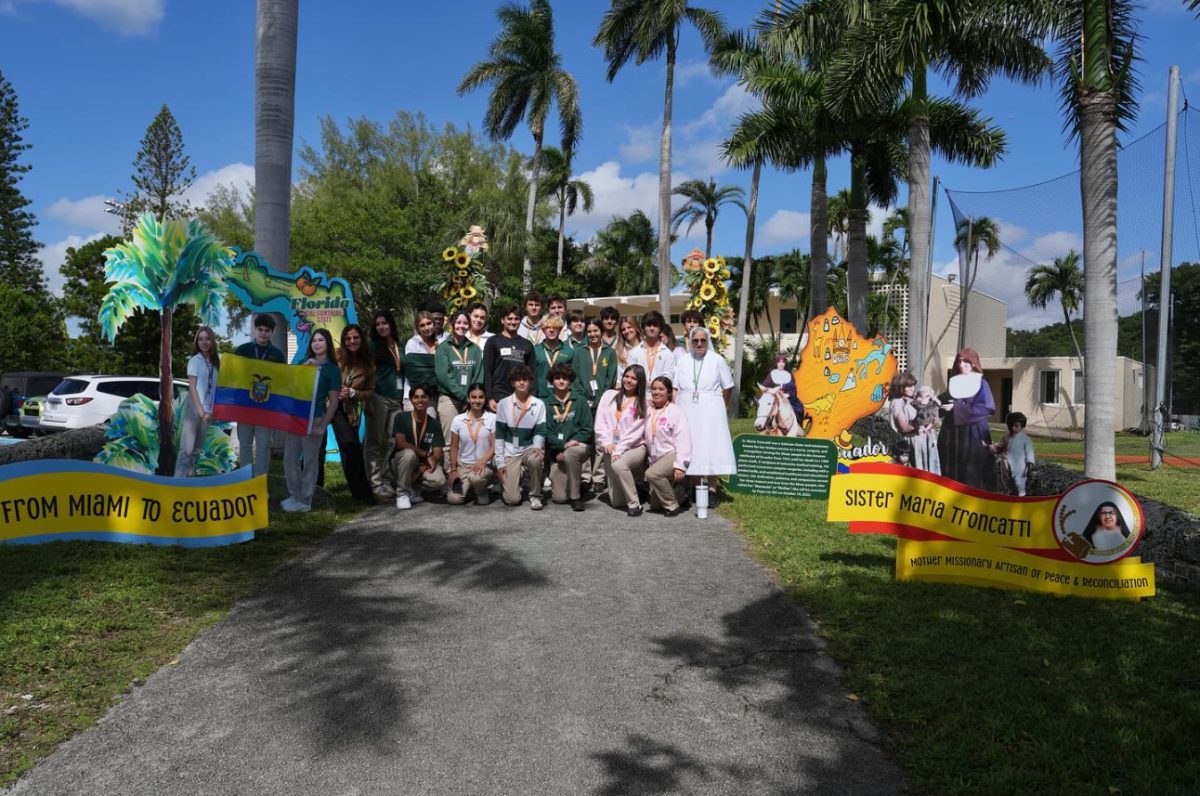 ILS students who are learning about Sr. Maria Troncatti in their theology classes pose for a photo next to the commemorative display located on the bridge to the 800 building.