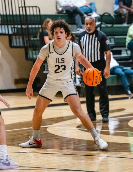 Focused and composed, a Royals' basketball player controls his pace on the court.