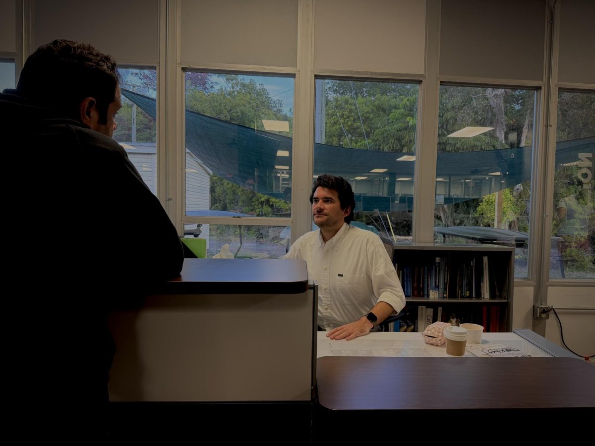 Mr. Suarez (right) and Mr. Moya (left) meet to discuss a new project at Mr. Suarez’s desk in the SLC, hopefully coming in February. They pine over the details and lightly negotiate before reaching a resolution, leaving both satisfied. 