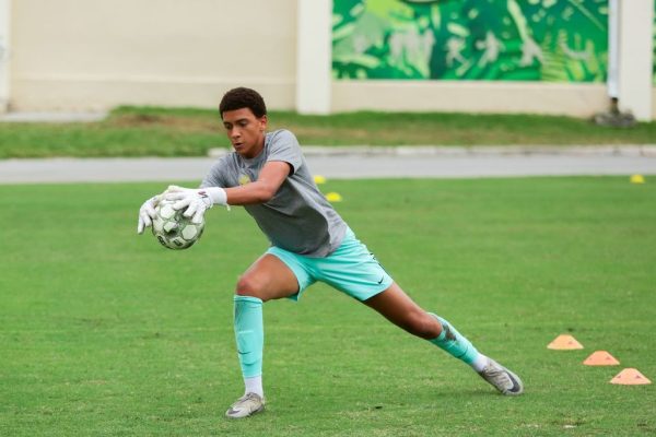 A goalie for the ILS Boys' Soccer team successfully catches a ball.