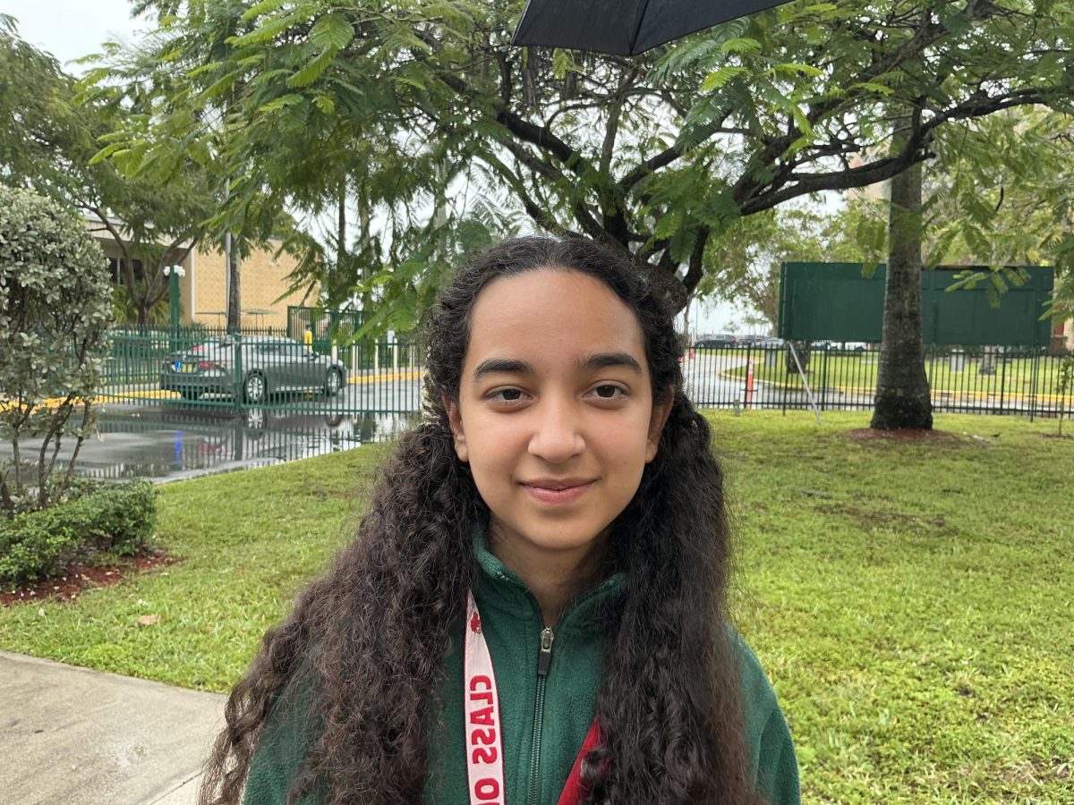 Clara pauses in a medium close-up as light catches her face.