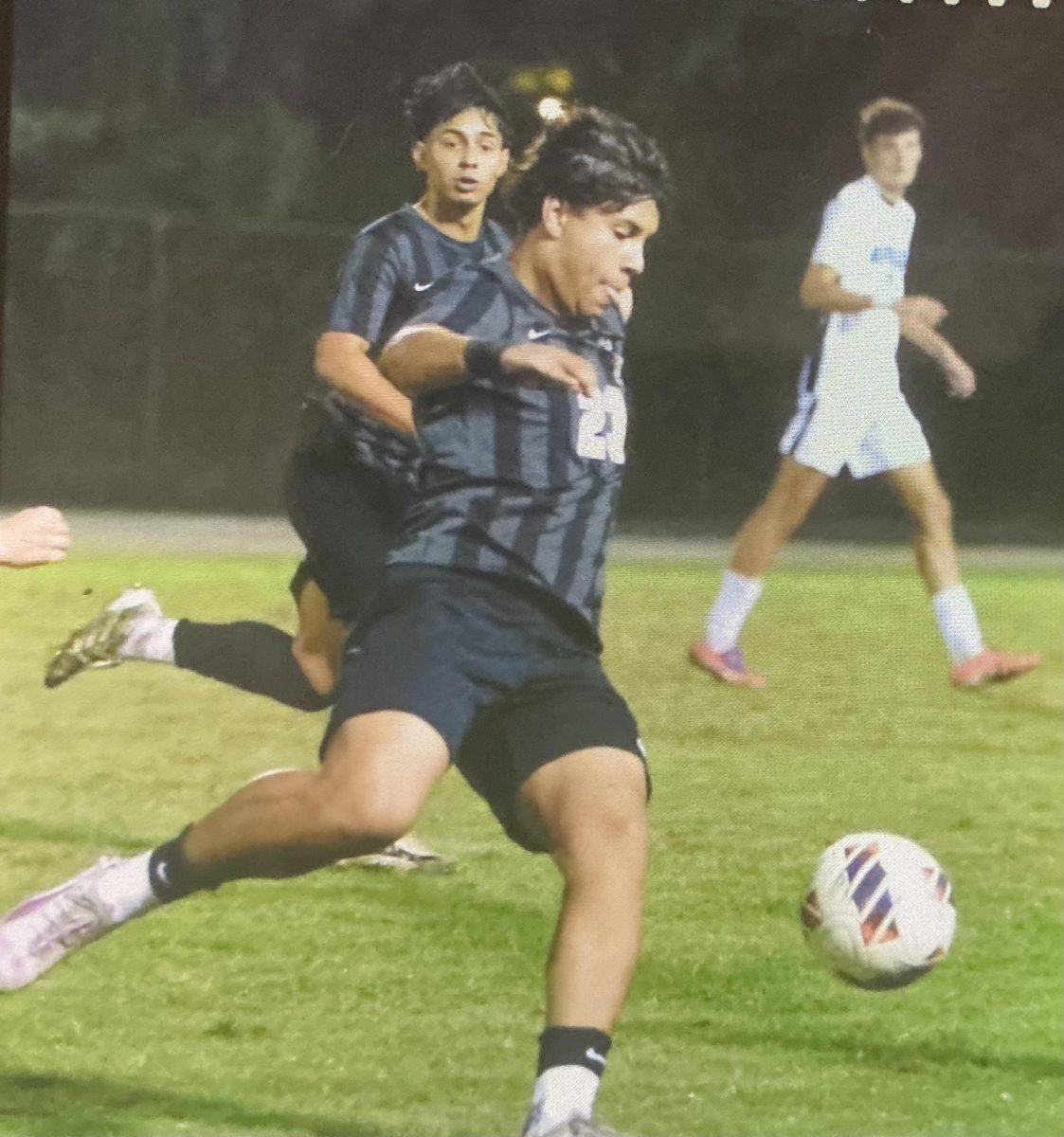 A Boys' Soccer team player receives the ball hoping to make a good play.