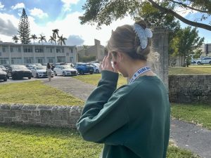 Student Luciana Gadala-Maria, Junior, adjusts her hair near the parking lot as she prepares to head to her next class.