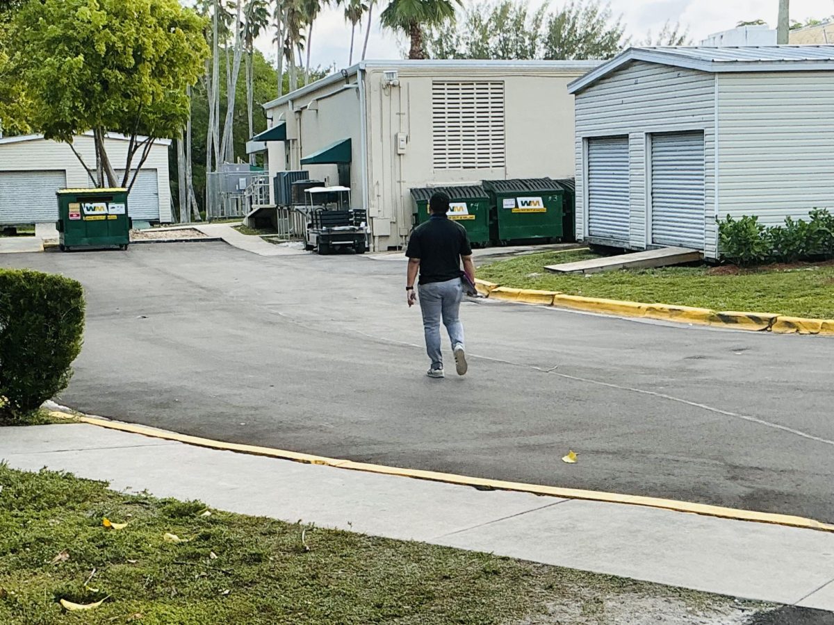 A teacher walks down the hallway alone during a transition between classes. Short breaks between periods often create calm moments before the next class begins.