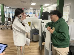 Enrique Diaz stops to talk with one of his friends and classmates, taking a moment to reconnect. Since his injury keeps him from being physically present in class, they use this time to catch up on everything he has missed.