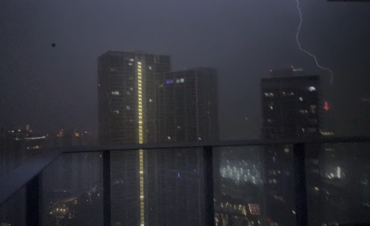 A dark storm dimly lit up by a long bolt of lightning.