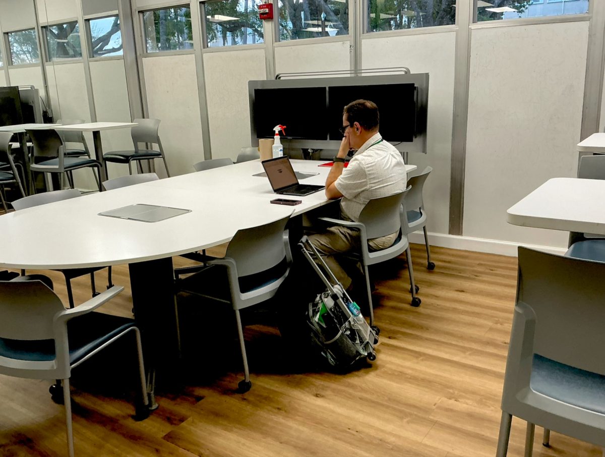 Teacher, works alone at a large table. The shot highlights the quiet environment of the learning center during off-peak hours.