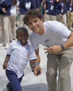 Senior Javier Martinez accompanies a visiting child on the way to the next rotation during FTK.
