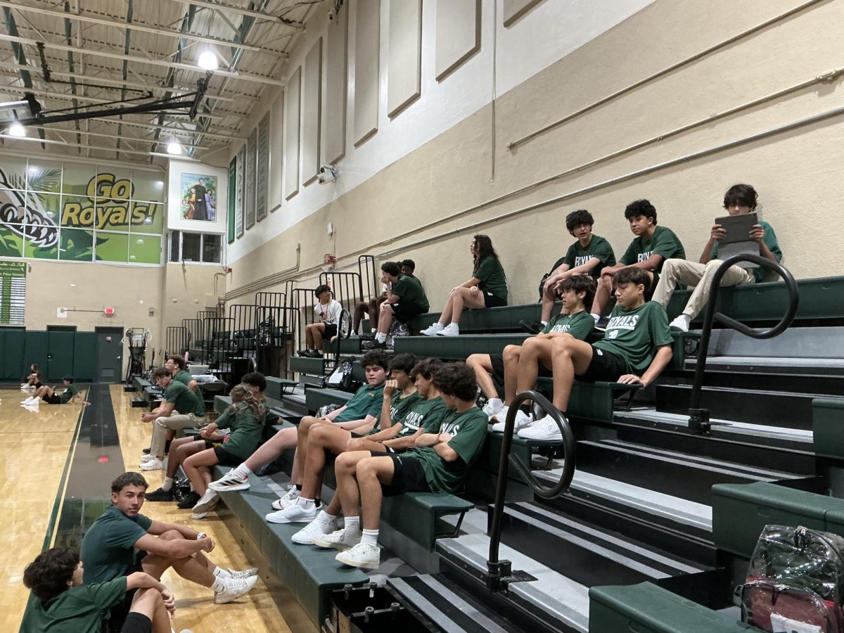 Class of 2029 relaxes on the bleachers in the gym while talking with friends and waiting for teachers announcement to begin the next task during PE/Team Sports. 