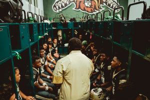 Team members gather to go over strategy and listen to pep talks in preparation.