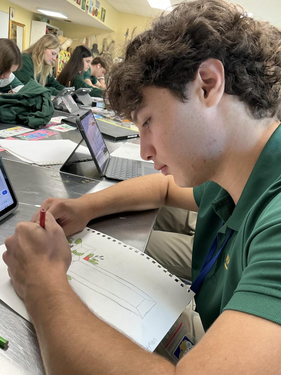 Junior Mark Gutman designs his cross with colored pencils, following his teacher, Ms. Wildenburgs instructions.