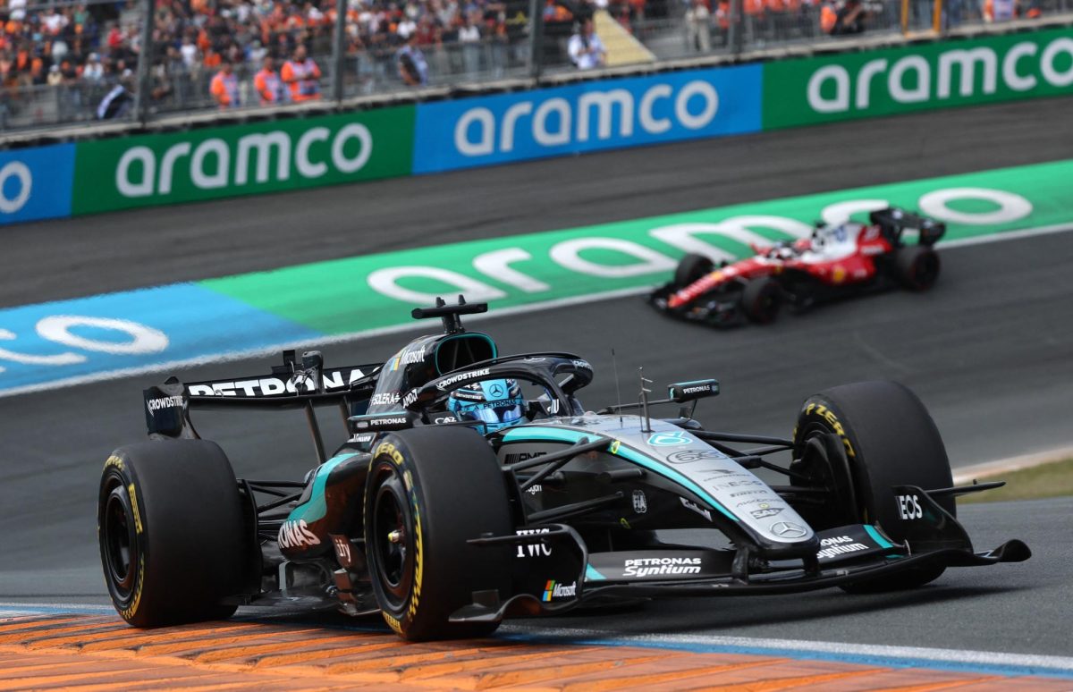 Mercedes driver George Russell exits a corner at high speeds as he is followed by a Ferrari.