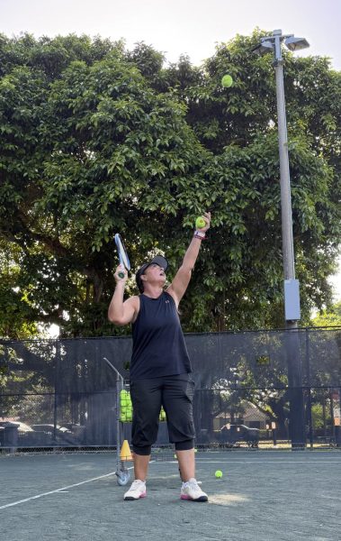 A tennis coach at Salvadore Park in Coral Gables teaches her players proper serving technique.