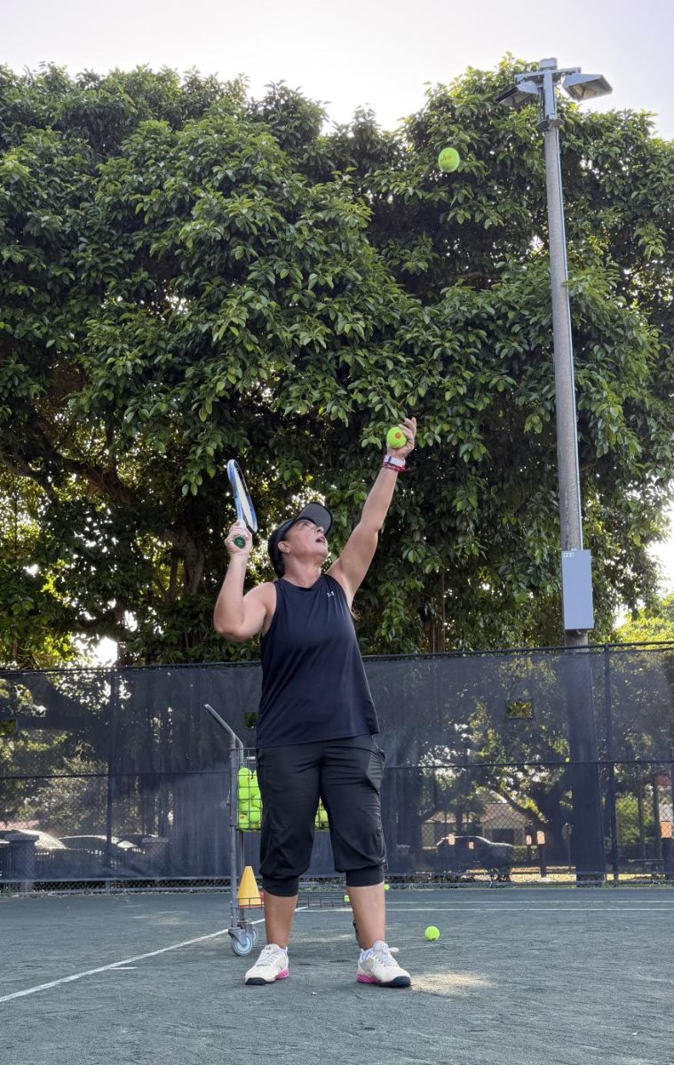 A tennis coach at Salvadore Park in Coral Gables teaches her players proper serving technique.