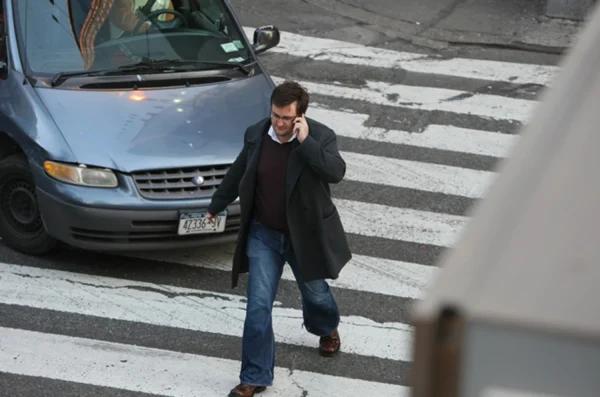 A typical example seen daily in streets across America and the world, a pedestrian crossing the street while using his cellphone.
