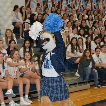 Lola the Bobcat, Lourdes Academy’s mascot, celebrates with students at an event.