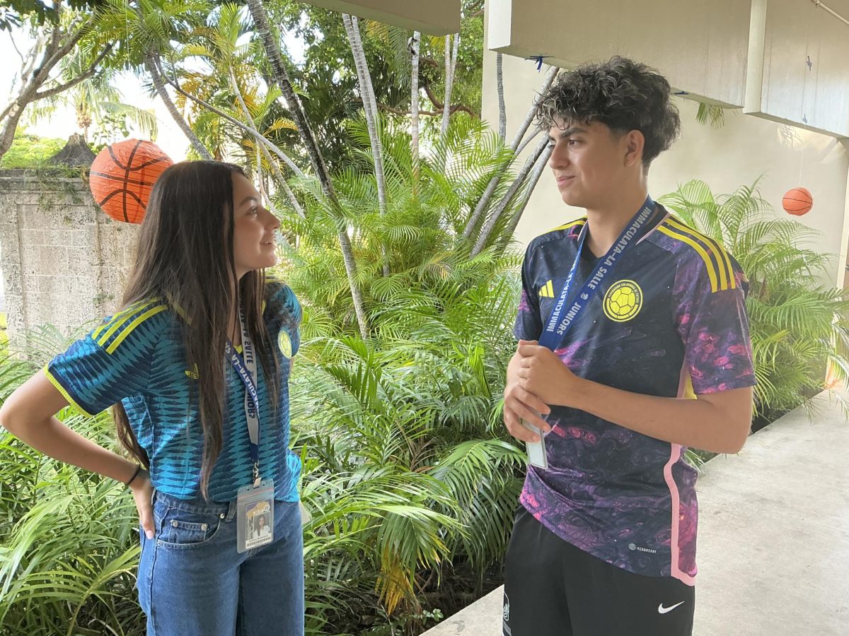 LTV members Michael Lopez and Andrea McNamara walk the halls talking about their next skit while wearing their theme of World Cup jerseys. 