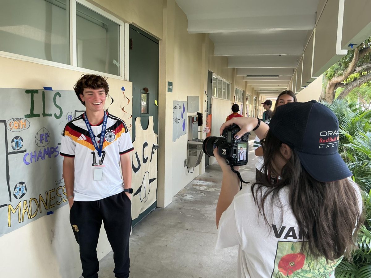 A yearbook member captures photo of a junior wearing a World Cup jersey for Hoco week.