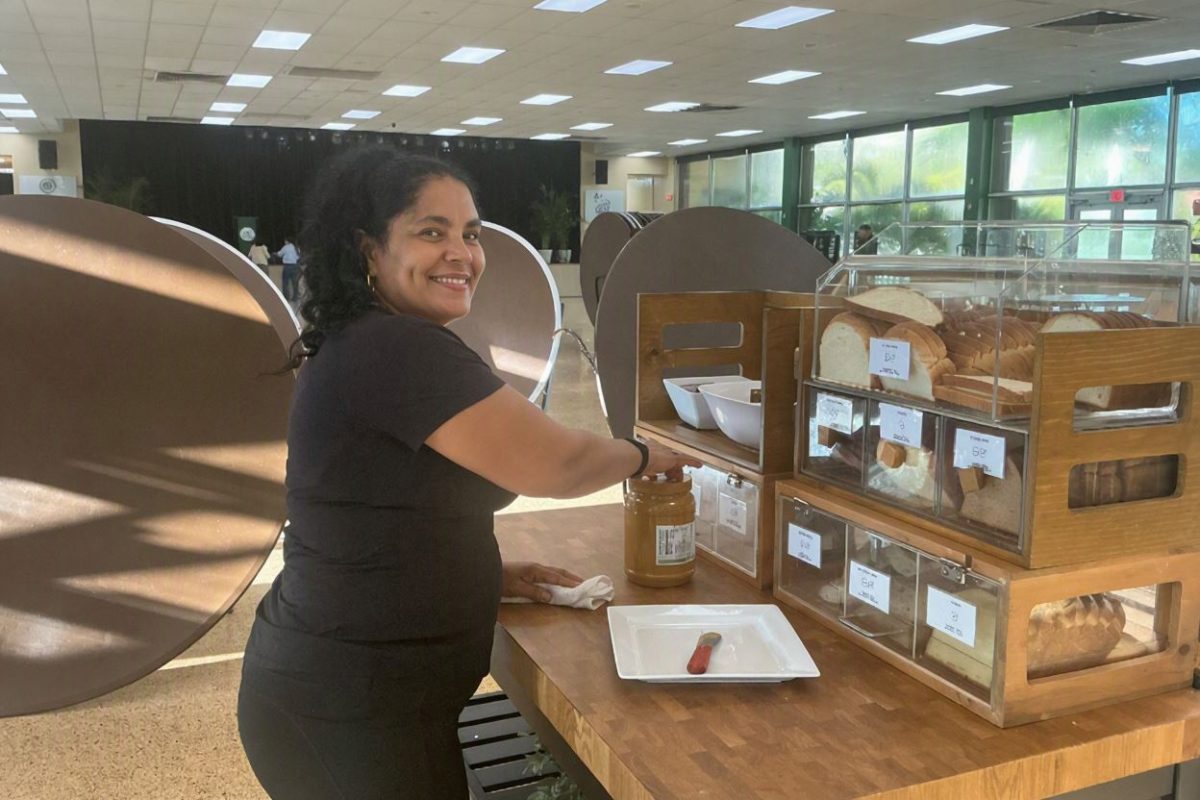 Campus maintenance staff member Ms. Caridad Benet organizes the cafeteria station, preparing fresh items and maintaining order for students and faculty throughout the day.