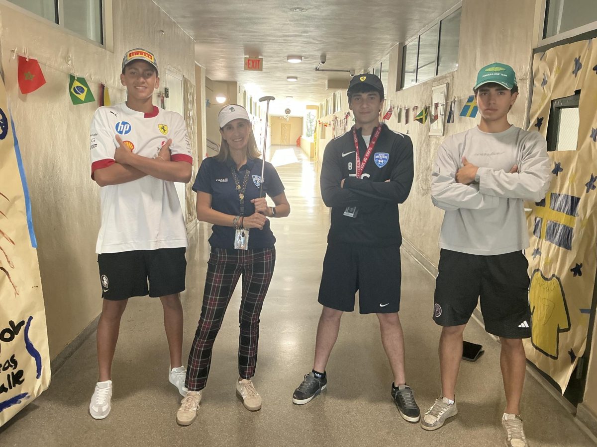 Ms. Rebeca Sordo is wearing golf clothes next to her senior students who are wearing Formula 1 apparel for Homecoming week's World of Sports.