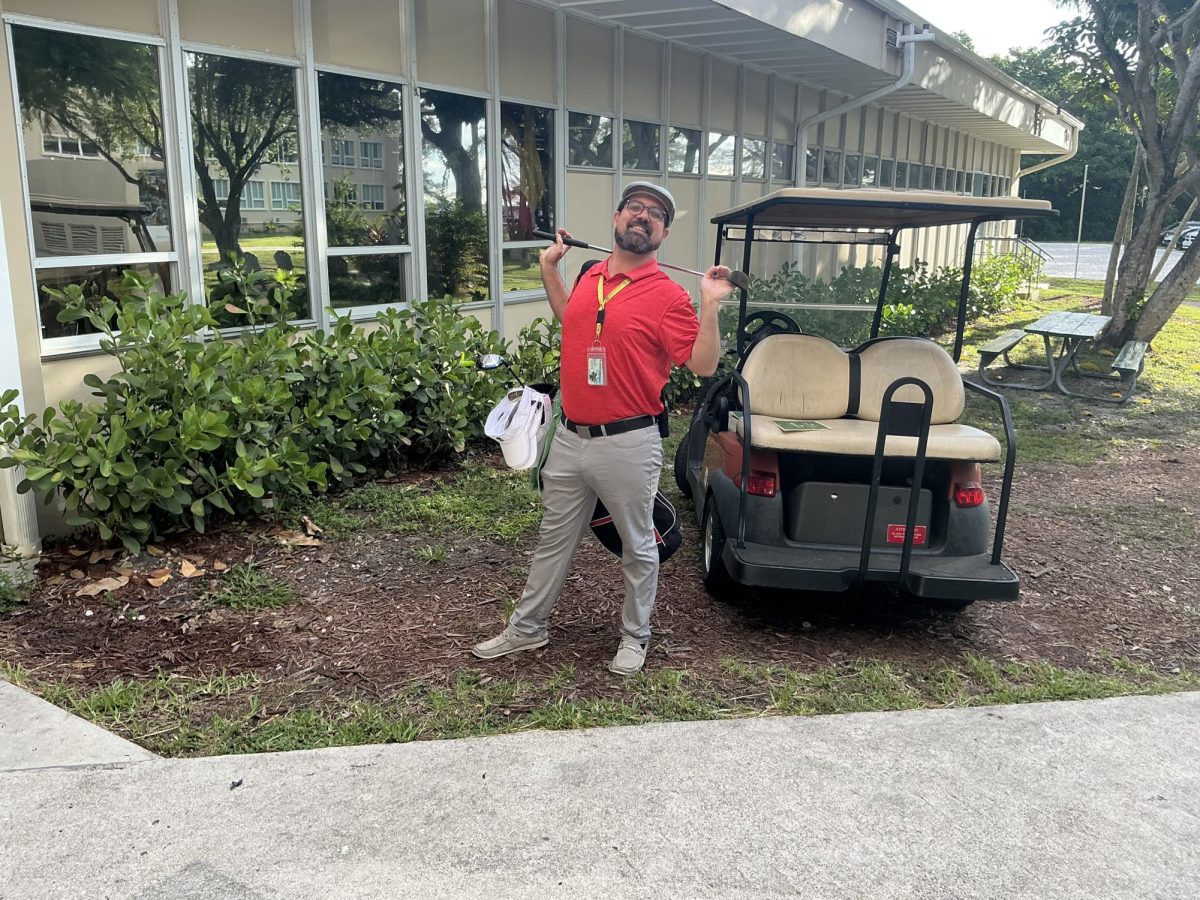 Mr. Tim Gamwell strikes a golfer's pose alongside a campus golf cart, equipped with a club and visor for the day's dress-up theme. School spirit themed days brought out creative outfits from both students and faculty throughout the week at Immaculata-La Salle.
