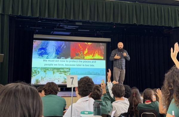 CLEO’s Senior Education and Outreach Manager, Mr. Owen Gaither, educates ILS students about the adverse impacts of climate change during in presentation in the school cafeteria.
