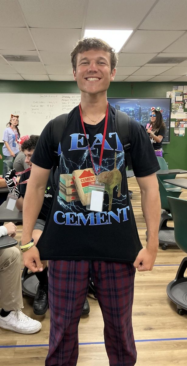 Senior Alejandro Escudero shows off his Tacky Tuesday look, pairing a graphic T-shirt with plaid pants for a mismatched outfit.