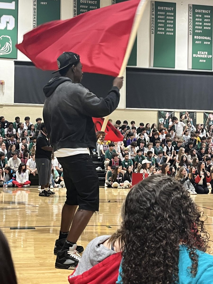 A senior waves a red flag during the senior skit.